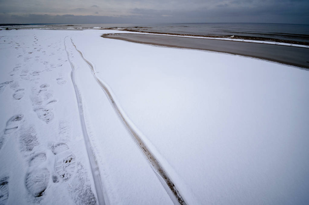 κατεψυγμένα αμμόλοφους στη θάλασσα με το ύδωρ πάγου και χιονιού στην αμμουδιά - Φωτογραφία, εικόνα