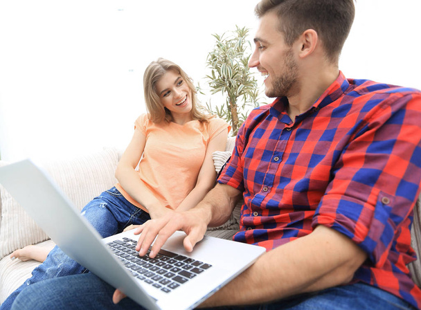 Happy modern couple surfing the net and working on laptop at home - 写真・画像