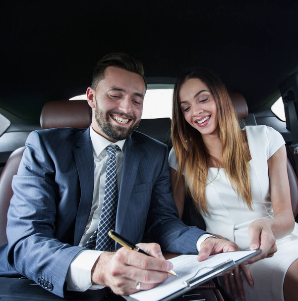 Beautiful business woman working with a client in the car - Photo, Image