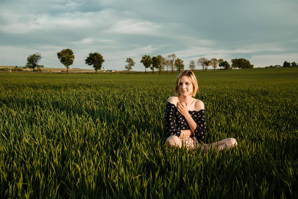 Young girl in a green field. Stylish girl. Green grass and blue sky. Emotional woman. plener. Travel. - Fotó, kép