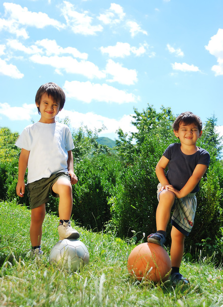 Two little kids with basketball and football - Фото, изображение