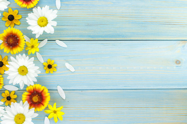 Margaritas blancas y flores de jardín en una mesa de madera desgastada azul claro. Espacio vacío en el otro lado
. - Foto, Imagen