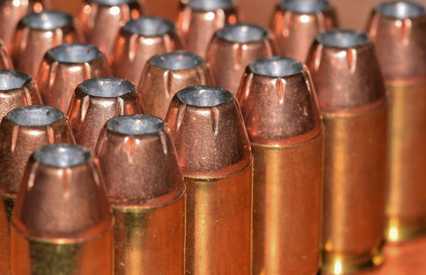 Several rows of hollow point .45 caliber handgun bullets standing up on their ends. - Photo, Image