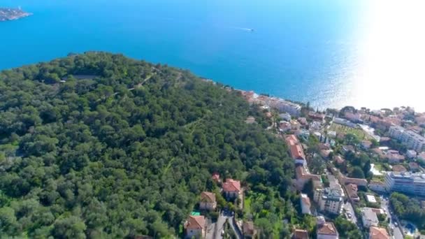 Μεσόγειο χωριό κοντά στο Νίκαια στους πράσινους λόφους στο φως του ήλιου. στέγες και τα στενά δρομάκια παρακάτω. βουνά και τη θάλασσα στο βάθος. Καλοκαίρι στη Γαλλία από την εναέρια προβολή κηφήνας 4 k - Πλάνα, βίντεο