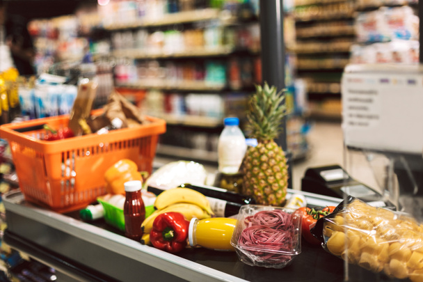 Lähikuva ostoskori ja tuoreita tuotteita kassalla työpöytä moderni supermarket
 - Valokuva, kuva