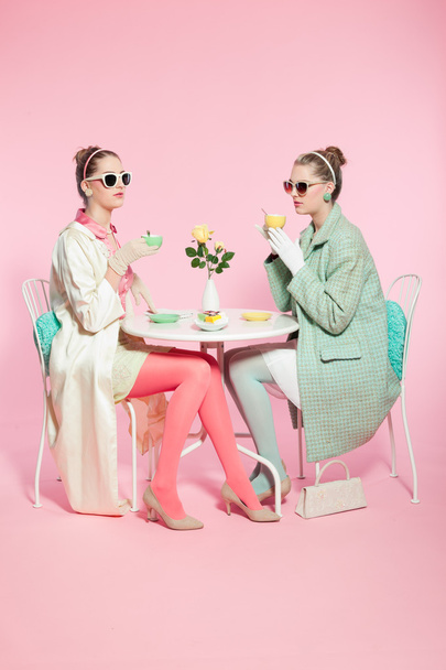 zwei Mädchen blonde Haare Fifties Mode Stil Tee trinken. - Foto, Bild