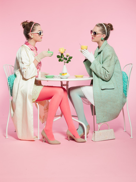 2 人の女の子金髪髪五十年代のファッションスタイルお茶を飲む. - 写真・画像