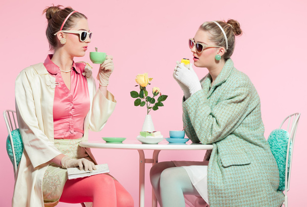 dwie dziewczyny blond włosy pięćdziesiątych moda styl picia herbaty. - Zdjęcie, obraz
