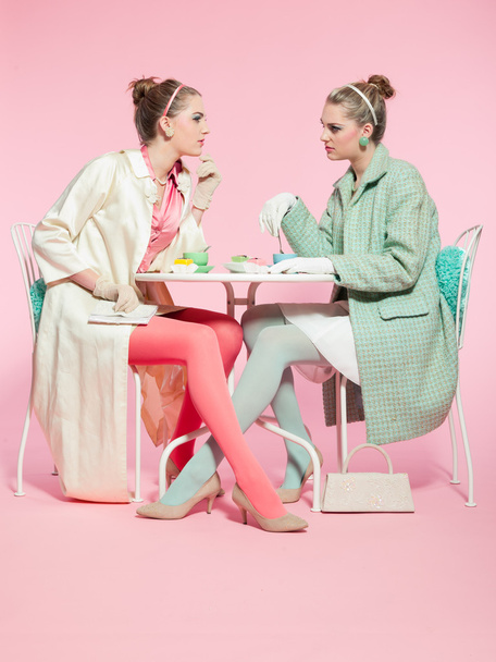 Две девушки светлые волосы пятидесятые мода стиле пить чай
. - Фото, изображение