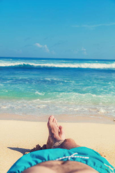 Ο άνθρωπος που απολαμβάνει την παραλία - εστίαση είναι στα πόδια. - Φωτογραφία, εικόνα