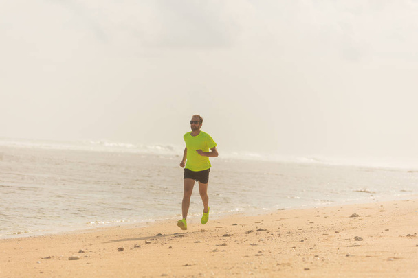 Correr en una playa de arena tropical cerca del mar / océano
. - Foto, Imagen