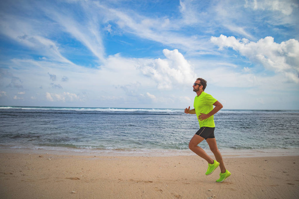 Correr en una playa de arena tropical cerca del mar / océano
. - Foto, Imagen
