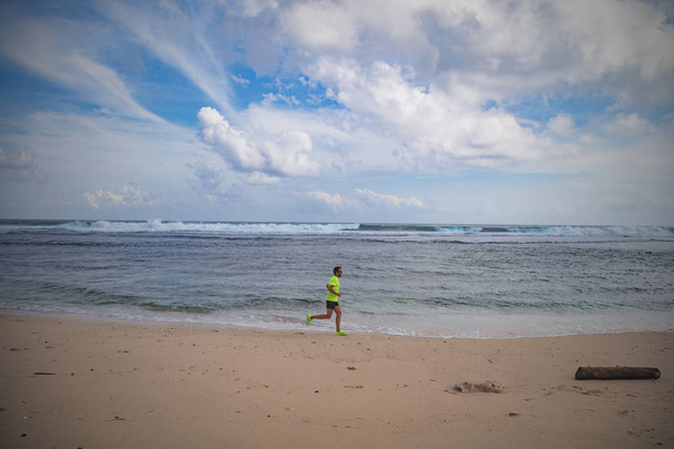 Jogging on a tropical sandy beach near sea / ocean. - Fotoğraf, Görsel
