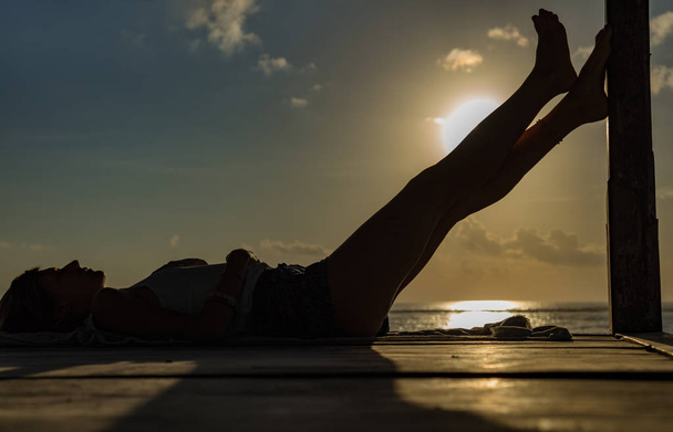 Κορίτσι απολαμβάνοντας το ηλιοβασίλεμα τροπικό ωκεανό / Ανατολή του ηλίου. - Φωτογραφία, εικόνα