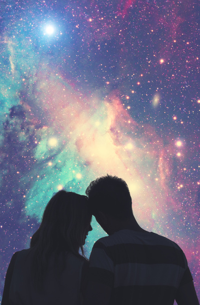 Σιλουέτες του ένα νεαρό ζευγάρι κάτω από τον έναστρο ουρανό. - Φωτογραφία, εικόνα