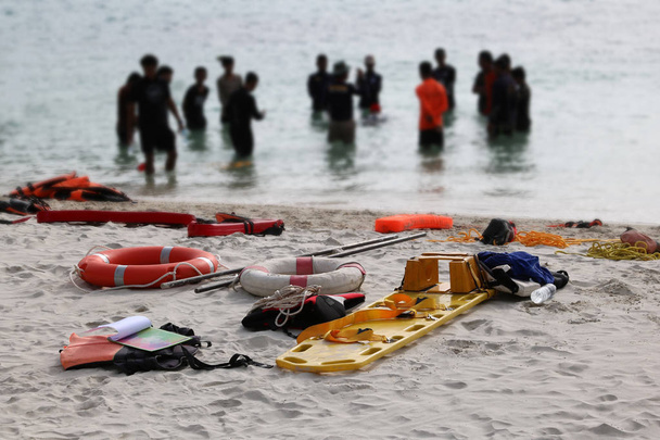 Medizinische Notfall-Werkzeugtasche oder Erste-Hilfe-Set am Strand mit Menschen, die Rettung und cpr Ausbildung oder praktischen Hintergrund. - Foto, Bild