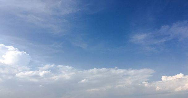 Prachtige wolken tegen de achtergrond van een blauwe hemel. Cloudscape hemel. Blauwe hemel met bewolkt weer, natuur wolk. Witte wolken, blauwe lucht en zon. - Foto, afbeelding
