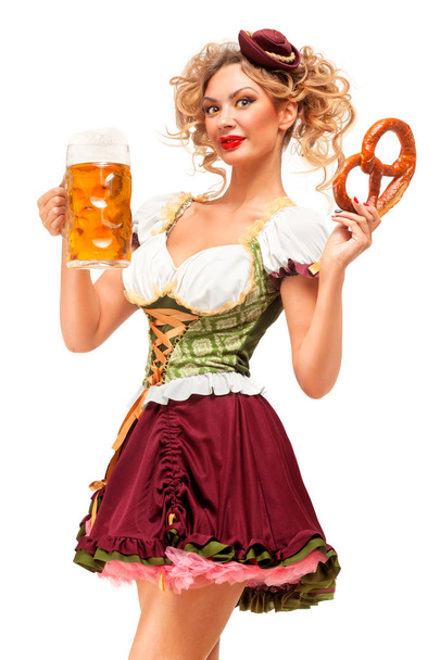 Creative concept photo of Oktoberfest waitress wearing a traditional Bavarian costume with beer and pretzel isolated on white background. - Photo, image