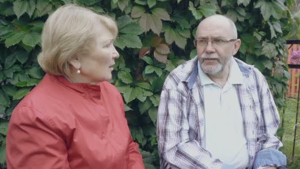 Starsze małżeństwo opowiada jak siedzą na ławce - Materiał filmowy, wideo