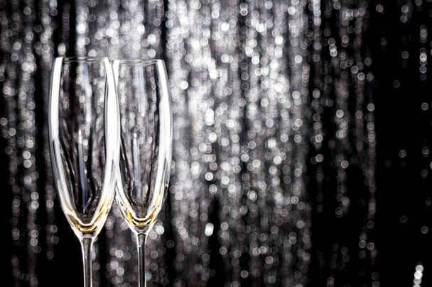 Boş şampanya veya şarap gözlük ile glitter Noel tinsel dekorasyon zemin üzerine. - Fotoğraf, Görsel