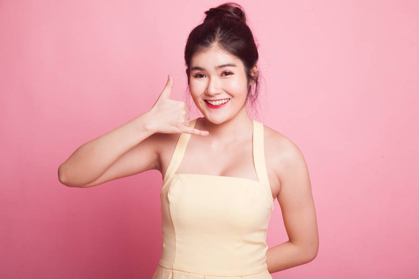 Young Asian woman show with phone gesture on pink background - Foto, Imagem