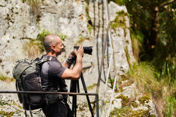 Valokuvaaja ammatillinen kamera ottaa kuvia vuorilla
 - Valokuva, kuva