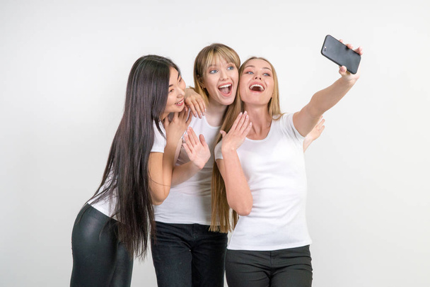 Belles filles drôles font selfie. Filles en T-shirts blancs
. - Photo, image