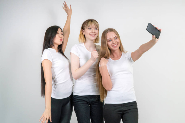 Beautiful funny girls make selfie. Girls in white T-shirts. - Foto, Bild