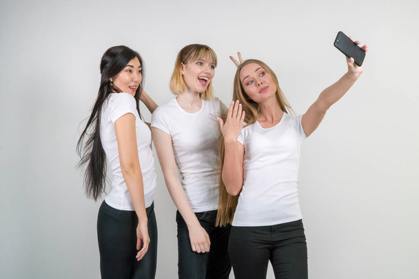 Beautiful funny girls make selfie. Girls in white T-shirts. - Φωτογραφία, εικόνα