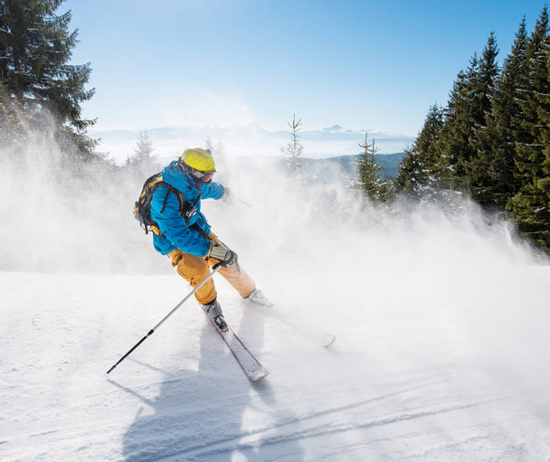 山でダウンヒル スキー スキーヤー。青のバック グラウンド スポーツ レクリエーション冬スキー リゾート人ライフ スタイル活発な活動アドレナリン装置概念の空と冬の森 - 写真・画像