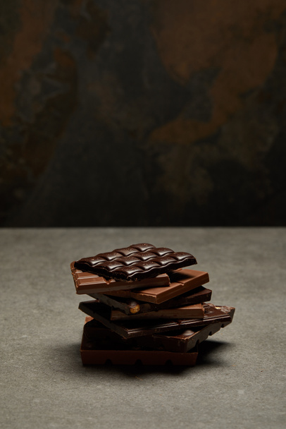 vue grand angle de morceaux de chocolat empilés assortis sur gris
 - Photo, image