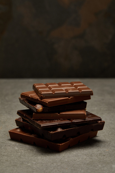 close-up view of sweet assorted stacked chocolate bars on grey  - Photo, Image