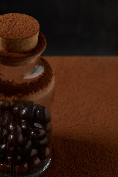 zbliżenie, wykwintne czekoladowe kulki w szkło słój i kakao w proszku  - Zdjęcie, obraz
