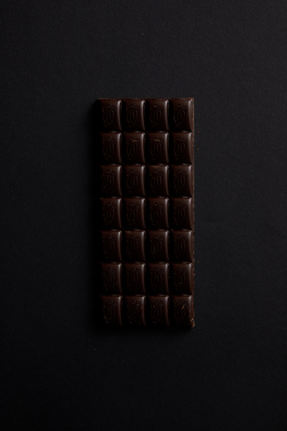 top view of gourmet bar of chocolate isolated on black - Foto, Bild