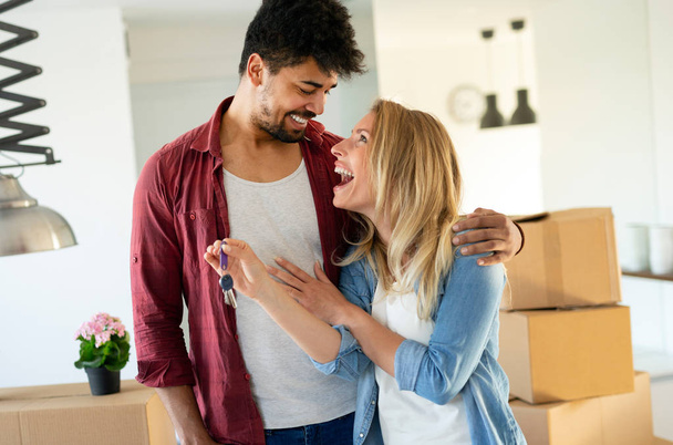 Couple enjoying their new luxurious home and hugging in living room - Foto, Bild
