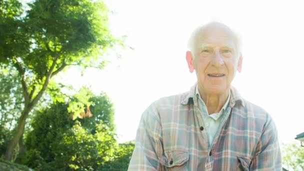 Backlit portrait of an active retired Senior Caucasian male gardener - Кадры, видео