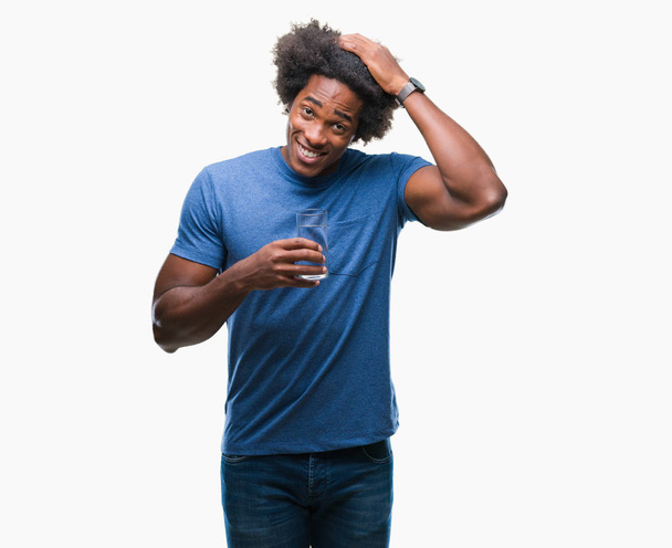 Afro amerikkalainen mies juo lasia vettä yli eristetty tausta stressaantunut käsin päähän, järkyttynyt häpeä ja yllätys kasvot, vihainen ja turhautunut. Pelko ja järkyttynyt virhe
. - Valokuva, kuva