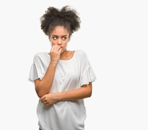 Young afro american woman over isolated background looking stressed and nervous with hands on mouth biting nails. Anxiety problem. - Foto, Imagem