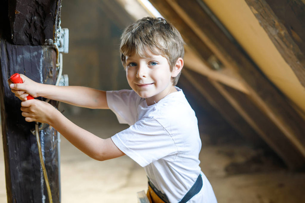 Niño pequeño ayudando con herramientas de juguete en el sitio de construciton
. - Foto, Imagen