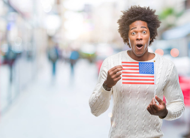 Afro american man flag of United States of America over isolated background scared in shock with a surprise face, afraid and excited with fear expression - Fotografie, Obrázek