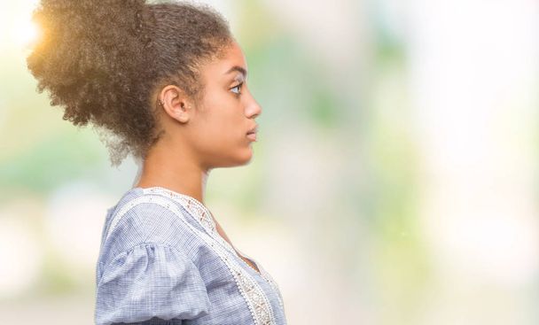 Młody afro american kobieta na białym tle patrząc w bok, zrelaksować się poza profil z naturalną twarz uśmiech i pewność siebie. - Zdjęcie, obraz
