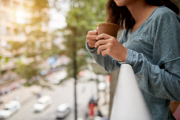 nő állt az erkélyen és a gazdaság csésze kávé  - Fotó, kép