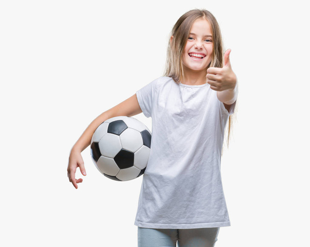 Młoda piękna dziewczyna gospodarstwa piłka nożna Piłka nożna na na białym tle szczęśliwy z uśmiechem robi znak ok, kciuk palcami, bardzo dobry znak - Zdjęcie, obraz