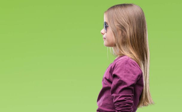 Fiatal gyönyörű lány visel napszemüveg elszigetelt háttér szeretnének oldalán, mint pihenni profil jelent a természetes arc, magabiztos mosollyal. - Fotó, kép