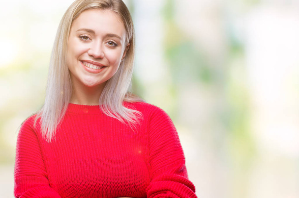 Nuori blondi nainen yllään talvi villapaita yli eristetty tausta onnellinen kasvot hymyillen ristissä kädet katsoen kameraan. Positiivinen henkilö
. - Valokuva, kuva