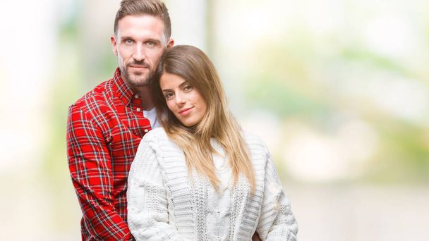 Mladý pár v lásce nosit zimní svetr izolované pozadí s vážným výrazem na tváři. Jednoduché a přirozené, při pohledu na fotoaparát. - Fotografie, Obrázek