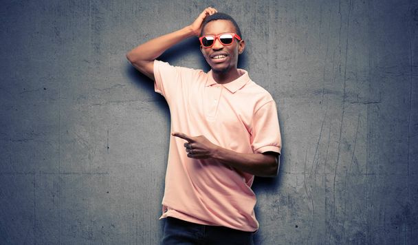 African black man wearing sunglasses pointing away side with finger - Photo, Image