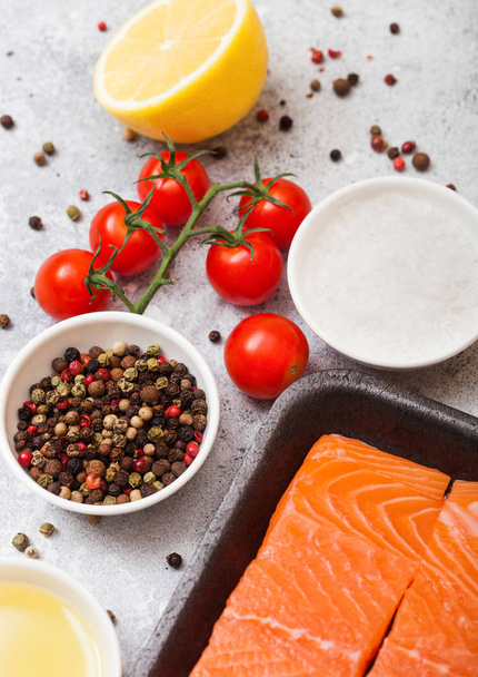Plastic container with fresh salmon slice with oil tomatoes and lemon on stone kitchen background - Fotografie, Obrázek