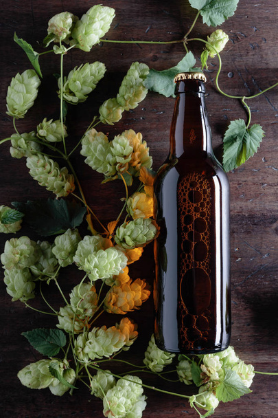 古い木製の背景上のホップとビールのボトル。平面図です。テキスト用の空き容量. - 写真・画像