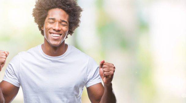 Afro-amerikai ember feletti elszigetelt háttér izgatott a siker karokkal emelt ünneplése győzelem mosolyogva. Győztes koncepció. - Fotó, kép